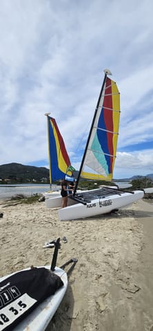Catamarán Hobie Cat con velas de colores en la arena de la playa de Ponta das Canas