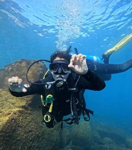 Diver giving the ok sign during an introductory dive at Ilha do Xavier