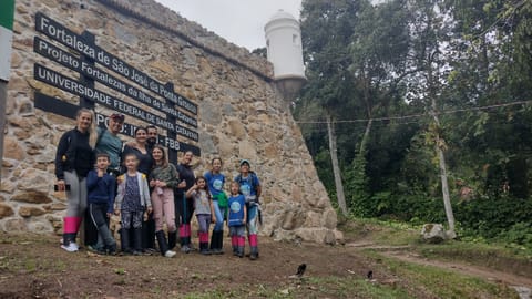 Grupo em frente a ruínas históricas na trilha Caminho da Santa Cruz